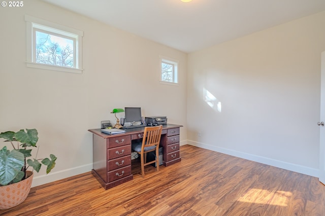 home office with baseboards and wood finished floors