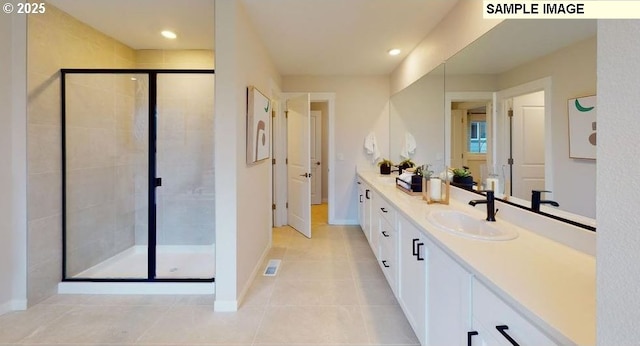 bathroom featuring a shower with door, vanity, and tile patterned flooring