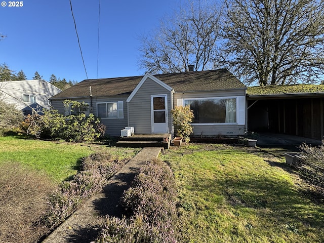 back of property featuring a carport and a lawn