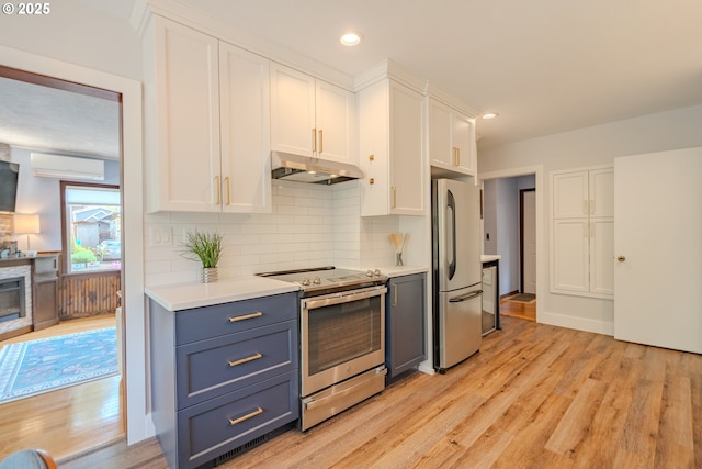 kitchen featuring under cabinet range hood, white cabinetry, appliances with stainless steel finishes, and light wood-style flooring