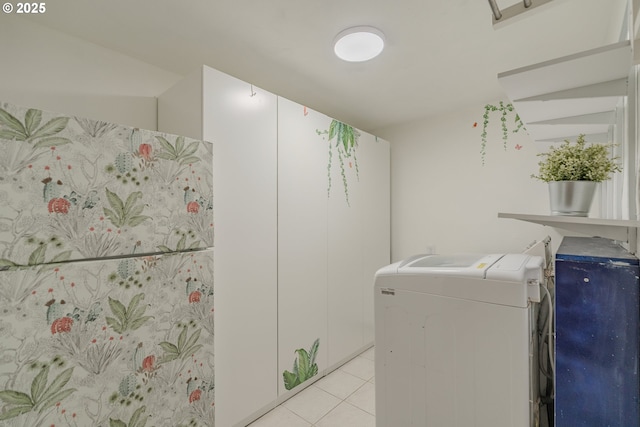 laundry room featuring light tile patterned floors, laundry area, and washing machine and clothes dryer