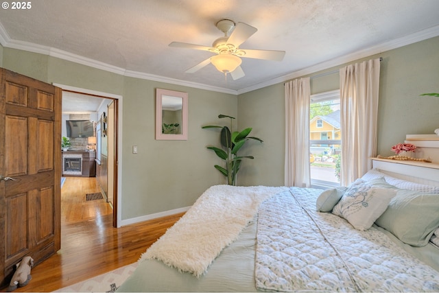 bedroom featuring visible vents, ornamental molding, and light wood-style flooring