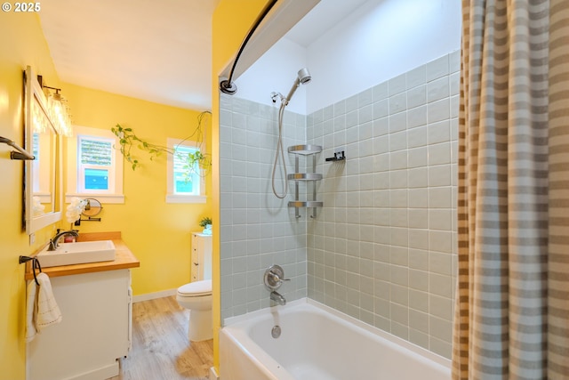 full bathroom with toilet, wood finished floors, shower / bath combo, and vanity