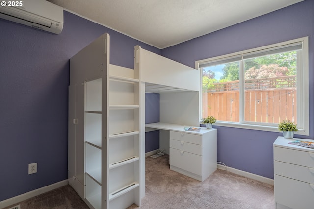 unfurnished bedroom featuring carpet flooring, an AC wall unit, and baseboards