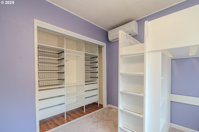 spacious closet featuring a wall mounted air conditioner and carpet