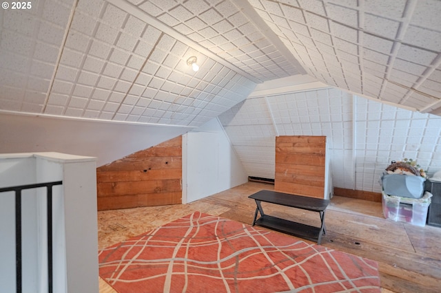 additional living space with wooden walls and lofted ceiling
