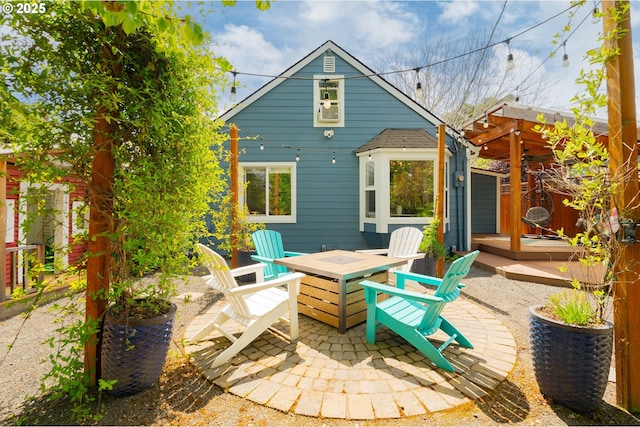 rear view of property featuring a patio area, a fire pit, and a deck