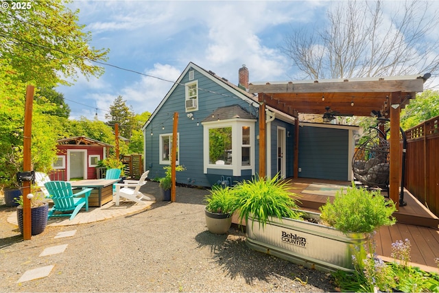 back of property featuring a ceiling fan, an outbuilding, a wooden deck, fence, and a patio