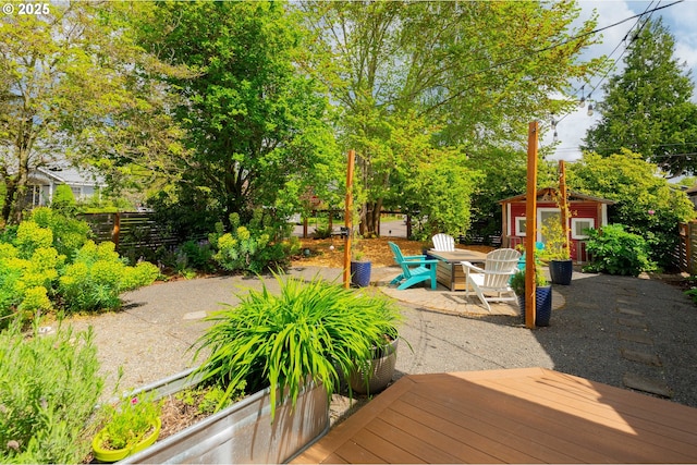 exterior space featuring fence, an outbuilding, a storage shed, and a patio