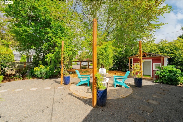 view of playground featuring fence, a patio, and an outdoor structure