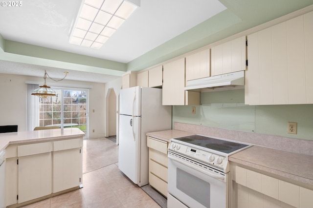 kitchen with cream cabinetry, light tile patterned floors, white appliances, and decorative light fixtures