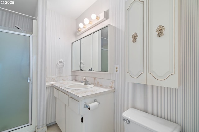 bathroom with walk in shower, vanity, and toilet