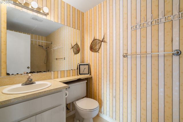 bathroom with vanity, toilet, and a shower