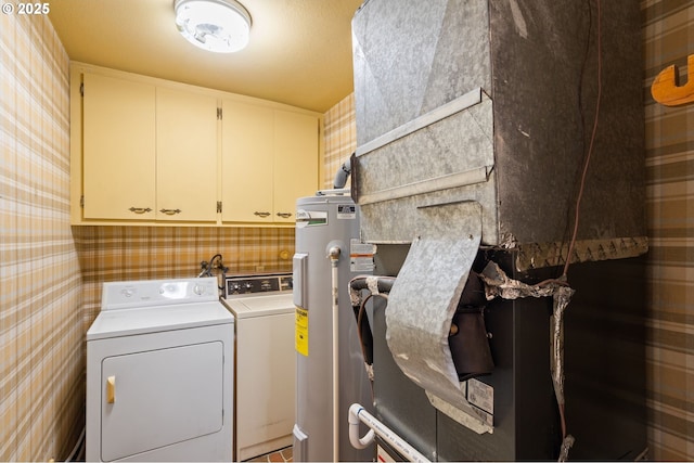 washroom with water heater, cabinets, and independent washer and dryer