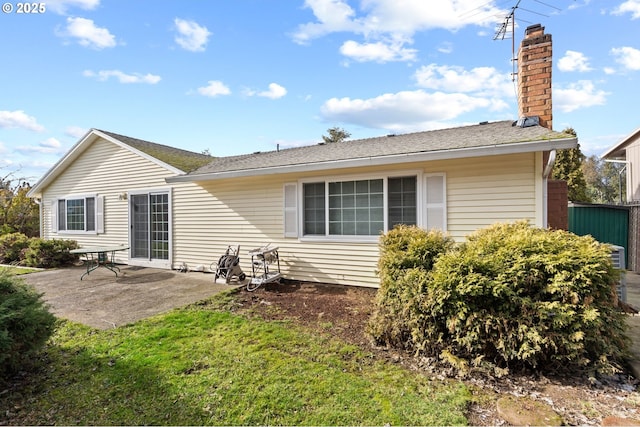 rear view of house featuring a yard and a patio