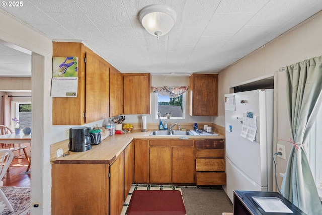 1387 Washington Ave, Coos Bay, OR 97420 - kitchen featuring freestanding refrigerator, light countertops, and brown cabinets