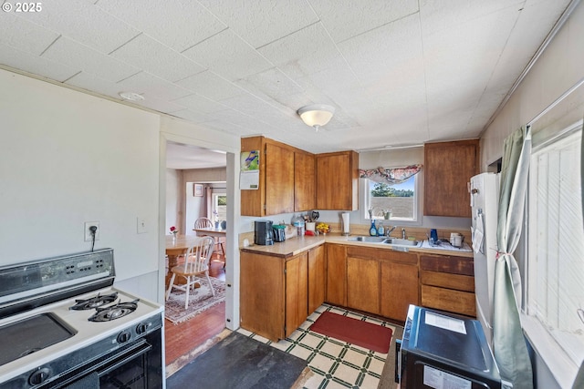 1387 Washington Ave, Coos Bay, OR 97420 - kitchen featuring white range with gas cooktop, brown cabinetry, light countertops, and light floors