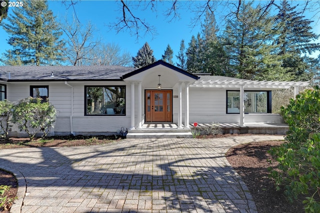 view of front of home featuring brick siding and roof with shingles