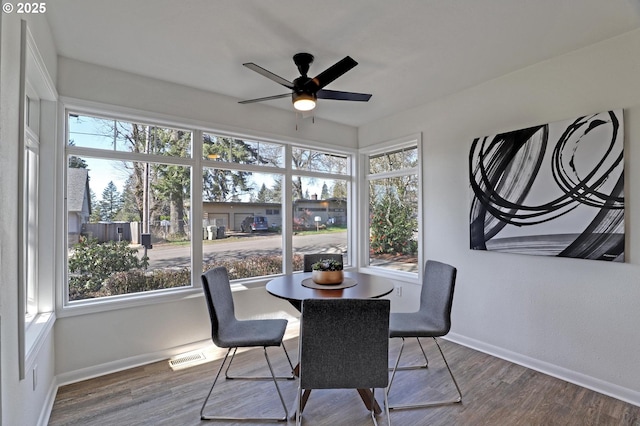 dining room with ceiling fan, wood finished floors, visible vents, and baseboards