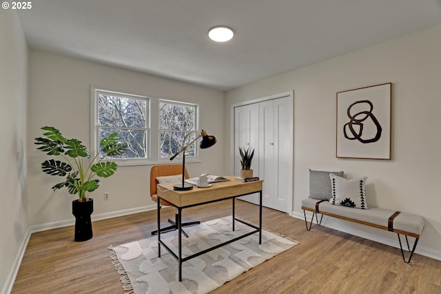 office space with light wood-type flooring and baseboards