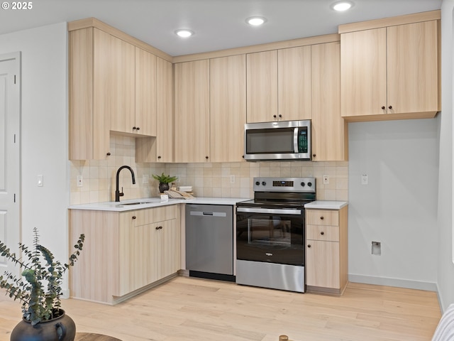 1616 SE Morrison St, Portland, OR 97214 - kitchen with appliances with stainless steel finishes, light brown cabinets, a sink, light wood finished floors, and light countertops