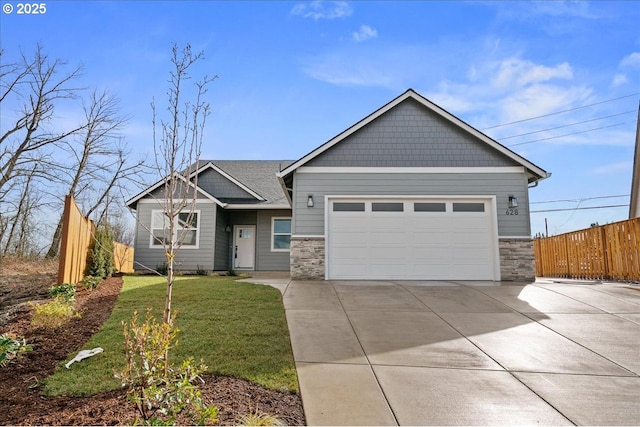 view of front of home featuring driveway, stone siding, an attached garage, fence, and a front yard