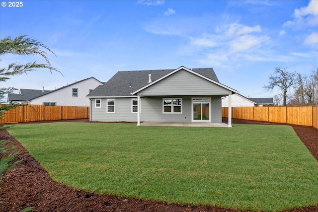 back of property with a shingled roof, a patio area, a lawn, and a fenced backyard