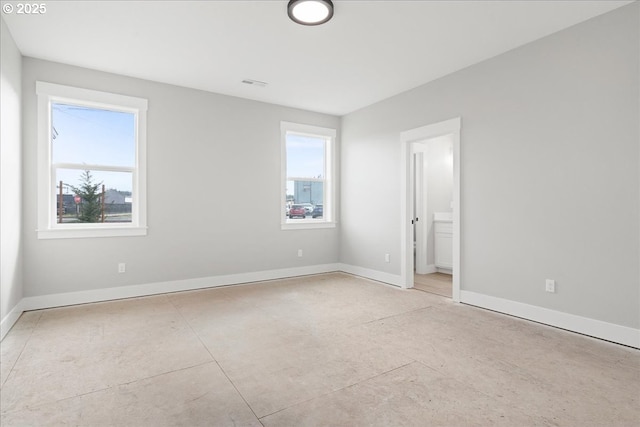 unfurnished bedroom with ensuite bath, visible vents, and baseboards