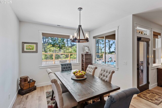 2130 Fir St, North Bend, OR 97459 - dining space with a chandelier, wood finished floors, and baseboards