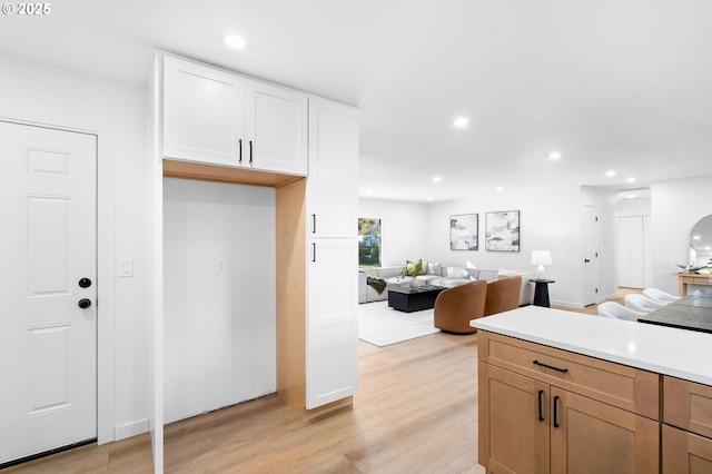 kitchen with light wood-type flooring and white cabinetry