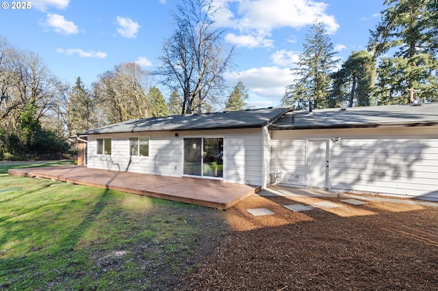 rear view of property featuring a lawn and a deck