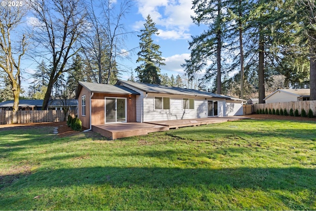 back of house featuring a lawn and a deck