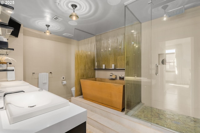 full bath with a shower stall, visible vents, and vanity