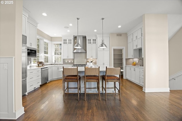 9037 NW Murdock St, Portland, OR 97229 - kitchen with stainless steel appliances, wall chimney range hood, a center island, dark wood finished floors, and backsplash