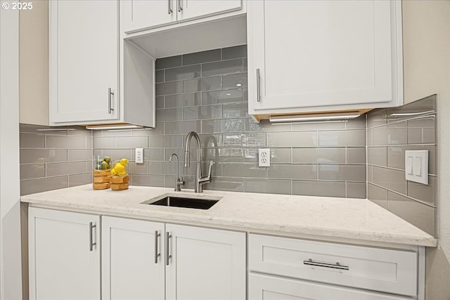 9037 NW Murdock St, Portland, OR 97229 - kitchen with a sink, backsplash, white cabinetry, and light stone counters