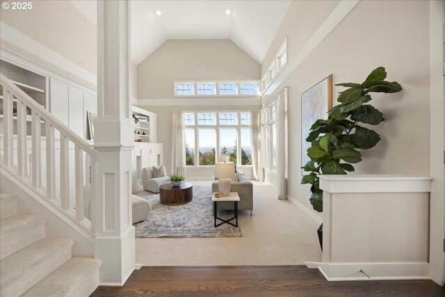 9037 NW Murdock St, Portland, OR 97229 - living area with ornate columns, high vaulted ceiling, stairs, and dark wood-type flooring