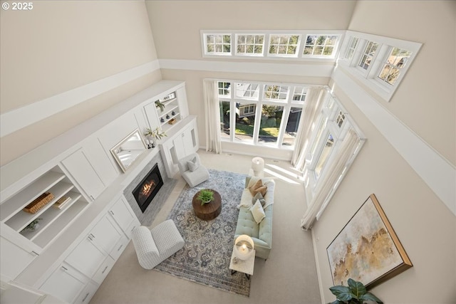 9037 NW Murdock St, Portland, OR 97229 - living area with a high ceiling, a lit fireplace, carpet floors, and healthy amount of natural light