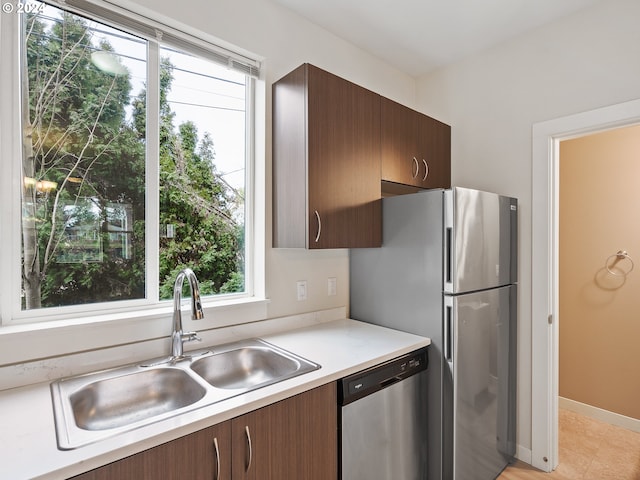 kitchen featuring appliances with stainless steel finishes, sink, and dark brown cabinetry