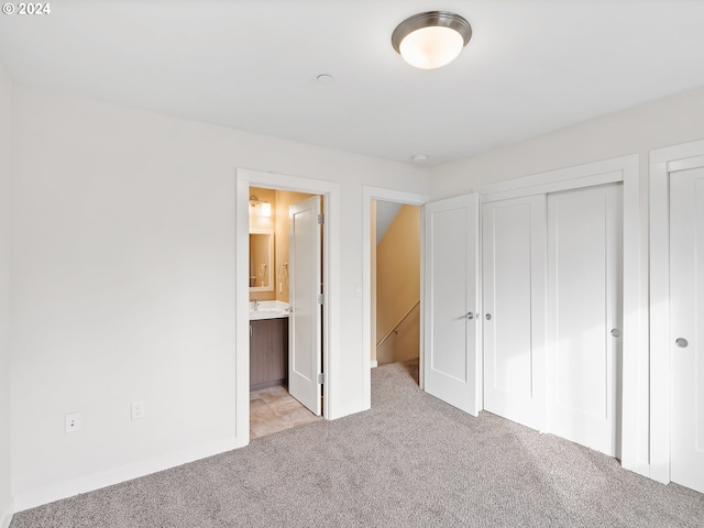 unfurnished bedroom with light colored carpet and ensuite bathroom