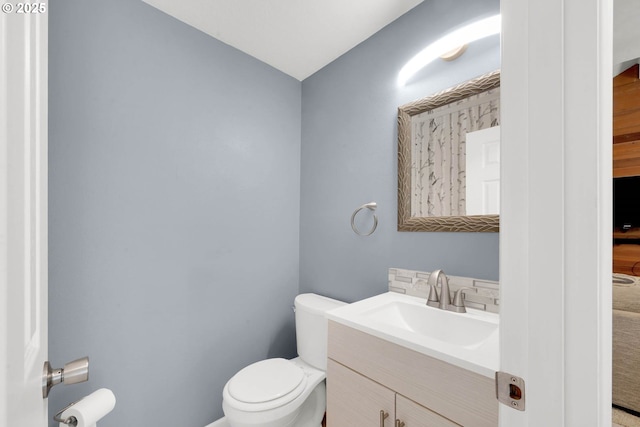 bathroom featuring backsplash, toilet, and vanity