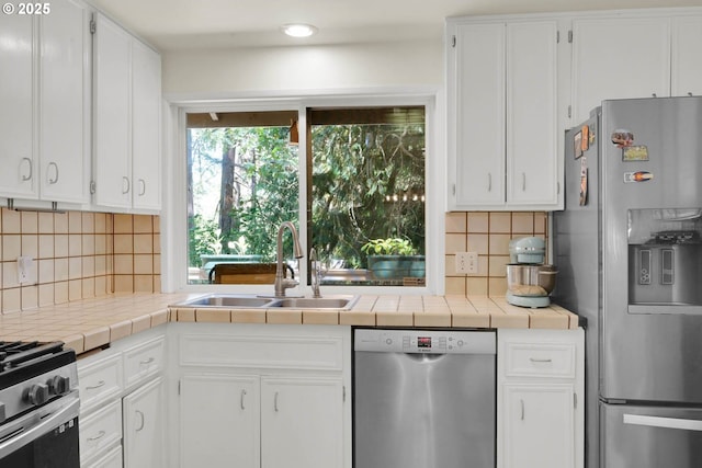 kitchen featuring sink, backsplash, stainless steel appliances, and tile countertops