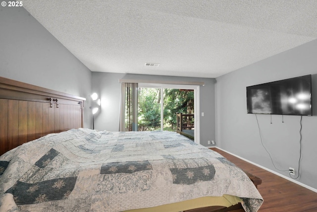 bedroom featuring a textured ceiling, wood-type flooring, and access to exterior