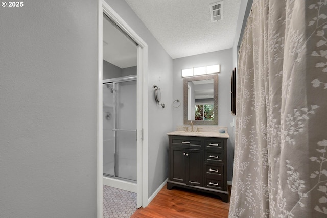 bathroom featuring a shower with curtain, hardwood / wood-style flooring, a textured ceiling, and vanity