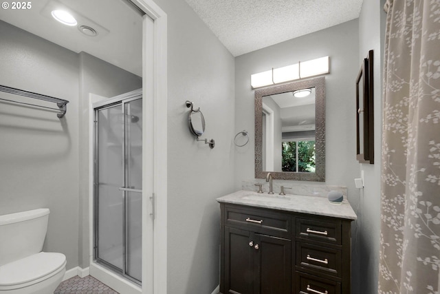 bathroom with vanity, a shower with shower door, a textured ceiling, and toilet