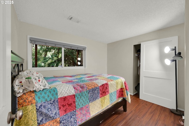 bedroom featuring dark hardwood / wood-style floors and a textured ceiling