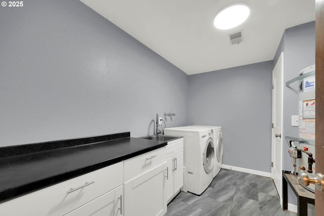 clothes washing area featuring sink, cabinets, and washer and dryer