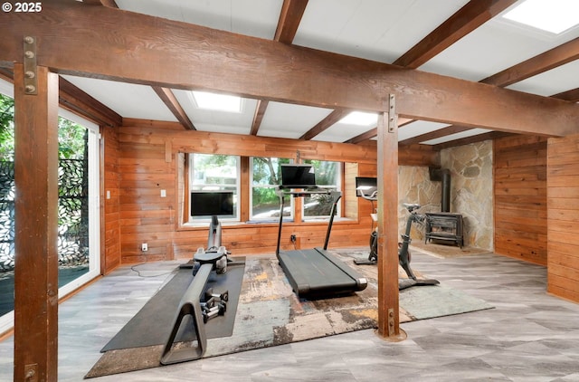 workout room with a wood stove and wood walls