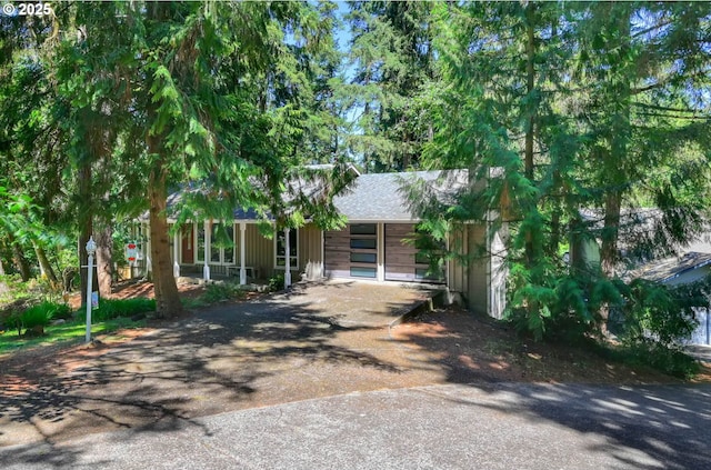 view of property hidden behind natural elements featuring a garage