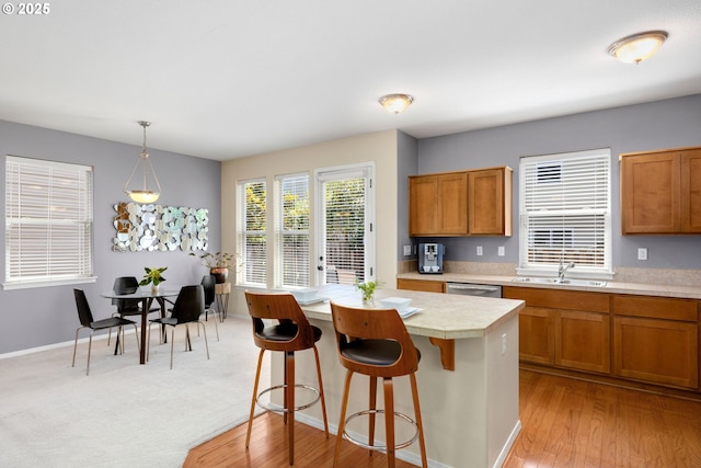 18646 SW Hideo Ct, Beaverton, OR 97003 - kitchen with a sink, brown cabinets, dishwasher, and hanging light fixtures