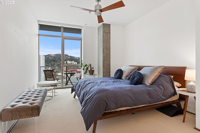 carpeted bedroom featuring floor to ceiling windows and ceiling fan